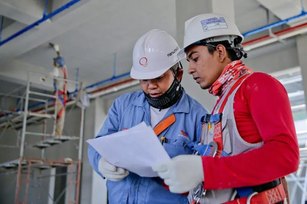 Construction workers reviewing plans on site