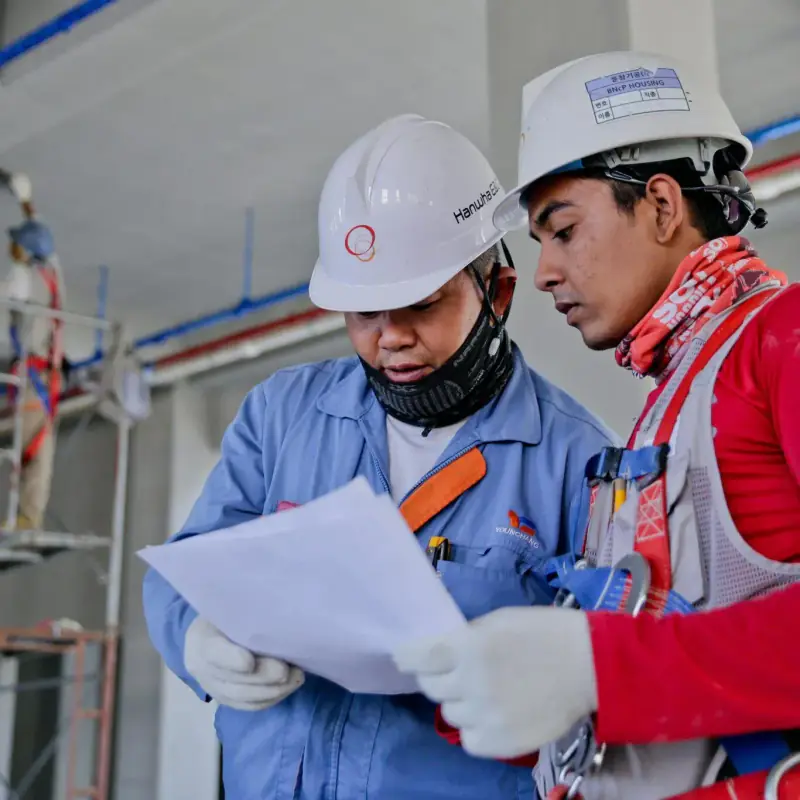 Construction workers reviewing plans on site